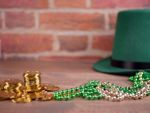 Golden Coins and Beaded Necklaces Beside a Leprechaun Hat