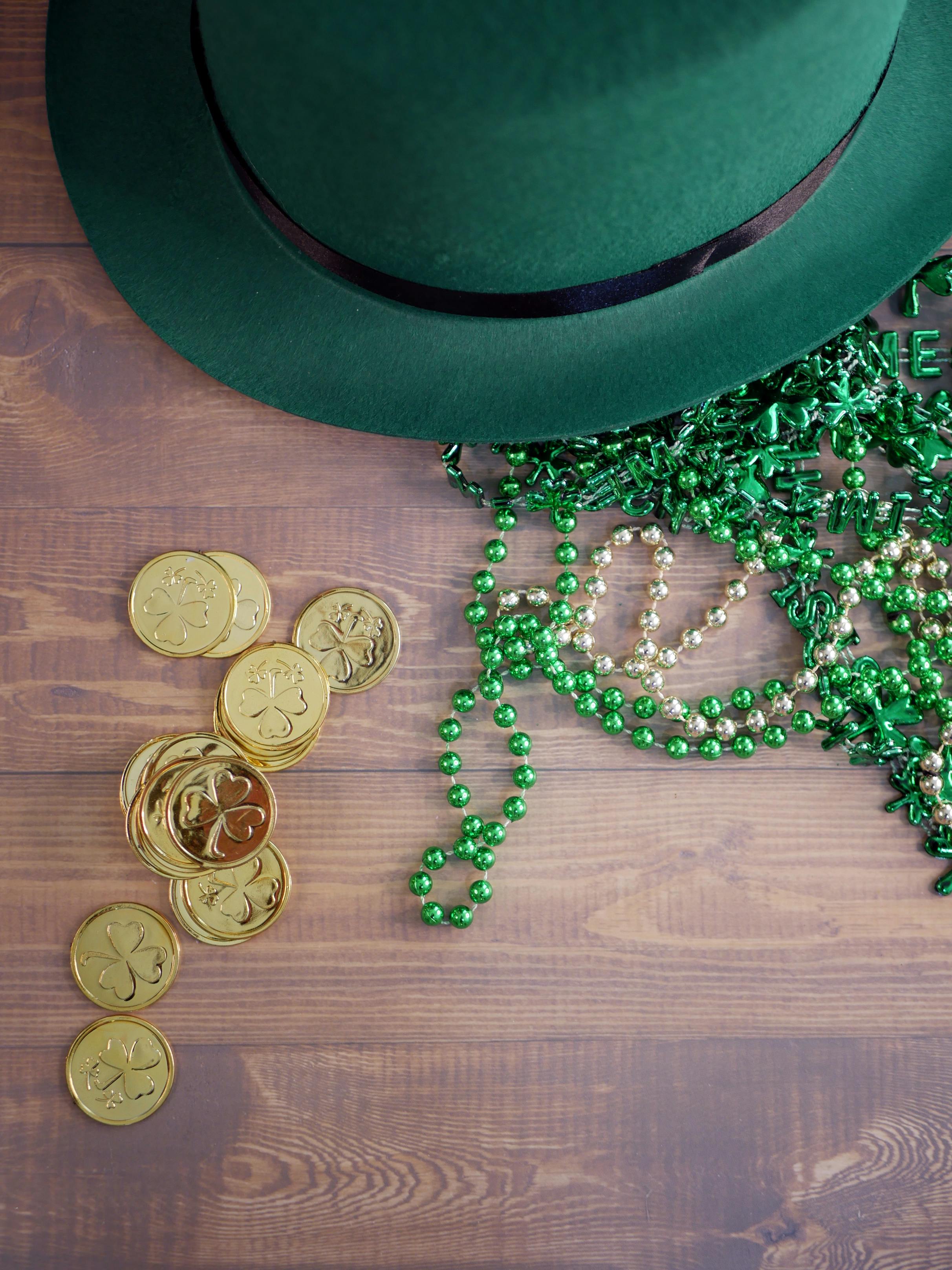 gold coins beside green and black hat