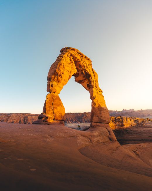 Captivating view of Delicate Arch in Utah glowing under a warm sunset sky.