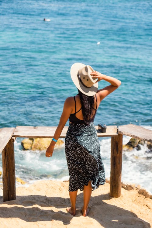 Back View of a Woman Holding her Hat 