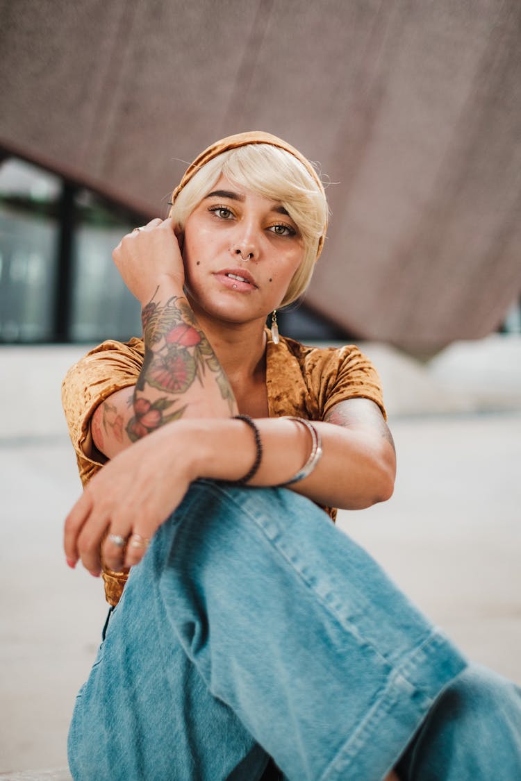 Tattooed Woman Sitting On Ground Of Empty Room