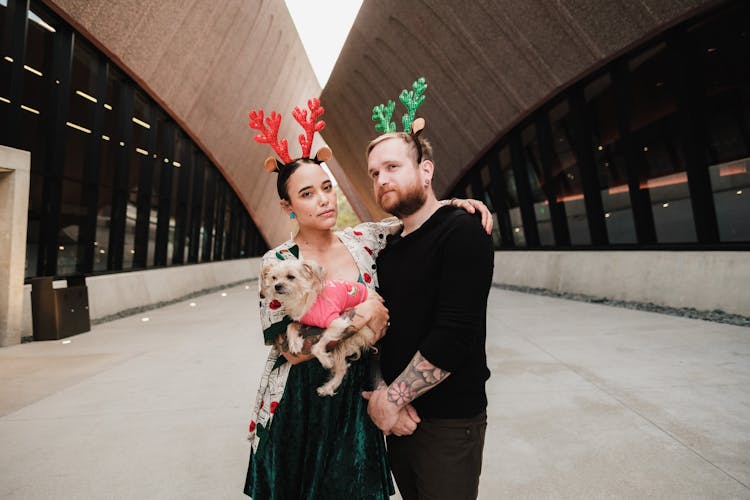 Couple With A Dog Wearing Reindeer Headbands