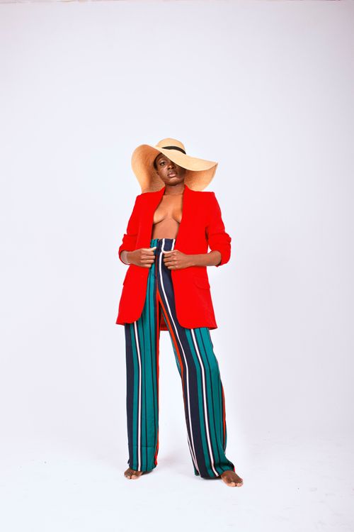 Free Stylish woman in a bold outfit poses confidently in a studio setting. Stock Photo