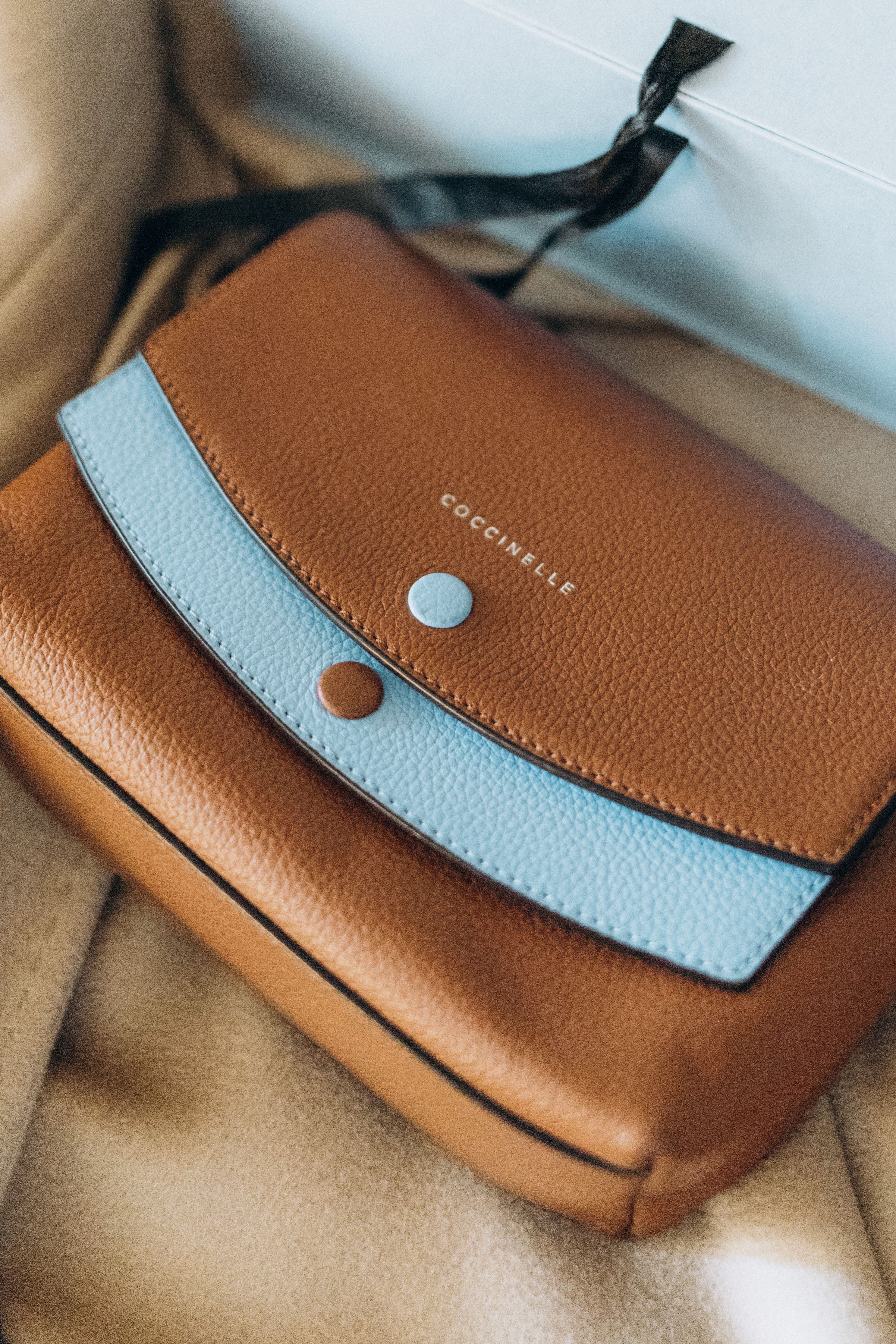 Elegante bolsa italiana de couro marrom e azul com design sofisticado e apelo de luxo.