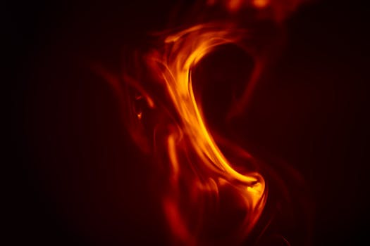 Close-up view of dancing flames with vivid orange and yellow colors, capturing the essence of fire's dynamic beauty.