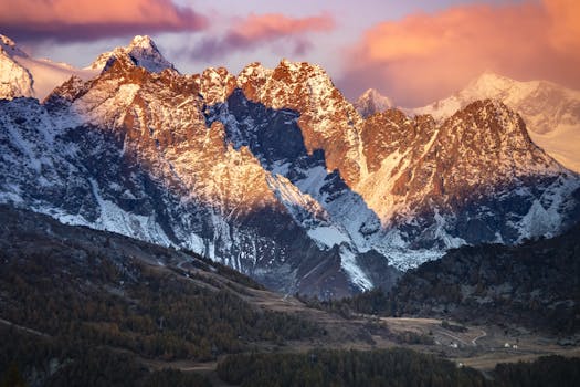 Majestic snow-capped mountains at sunset with vibrant skies and scenic landscape.