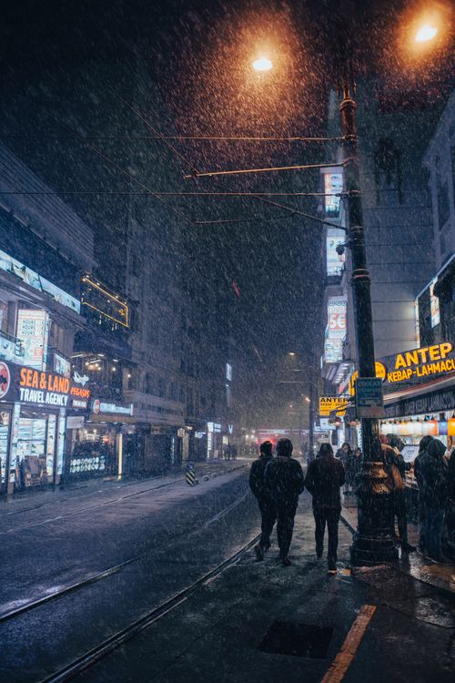 Free A snowy winter evening on a bustling city street in Istanbul, captured under streetlights. Stock Photo