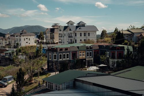 Free Aerial view of a picturesque town with modern buildings against a mountainous backdrop. Stock Photo