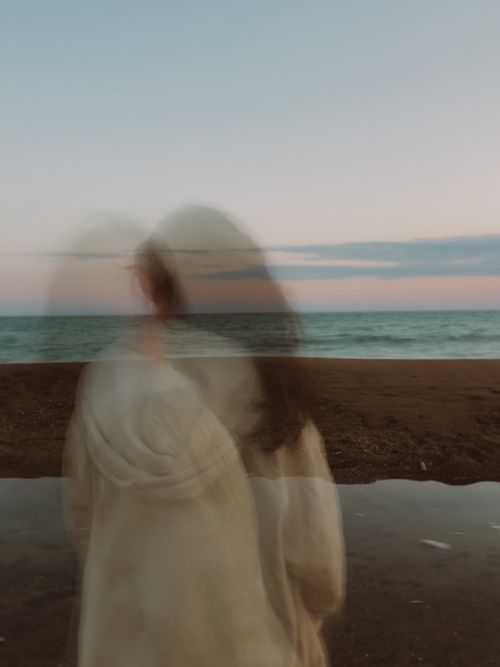 Free A blurred silhouette of a person at the beach during twilight, capturing motion and tranquility. Stock Photo