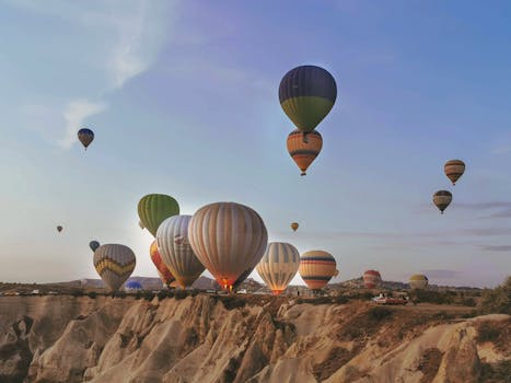 Hot air balloons soaring over Cappadocia's unique rock formations during sunset.