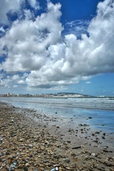 Cloudy day at the pebbled beach of Tangier, showcasing the vast sea and skyline.