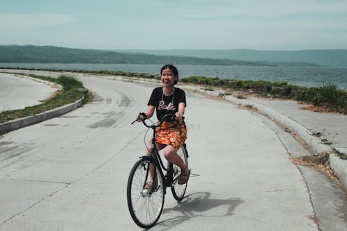 Woman in a Black Shirt Riding a Bike