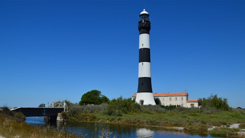 Lighthouse on Shore against Blue Sky