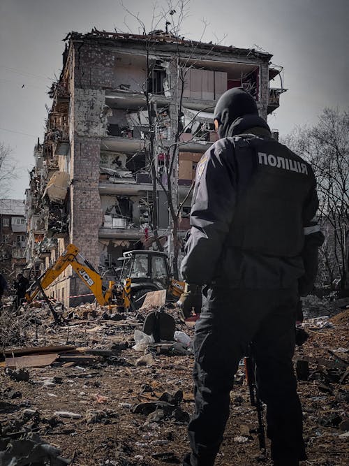Free Policeman Beside Destruction of a Residential Building in Kyiv Stock Photo