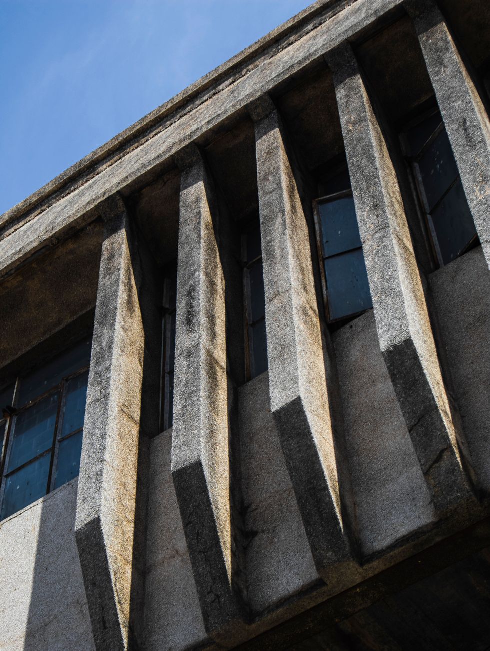 Close-up of a brutalist building facade showcasing geometric concrete design and shadows.. close, brutalist, building
