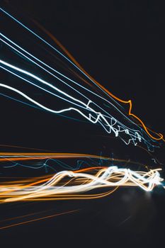 Vibrant light trails capture urban motion at night, showcasing long exposure photography.