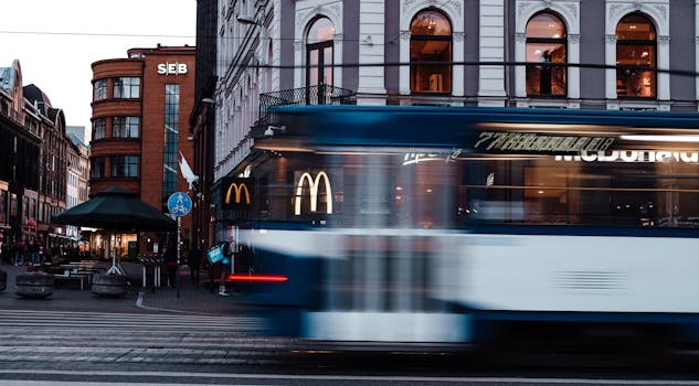 Blurred tram in front of classic architecture and McDonald's in Riga, Latvia.