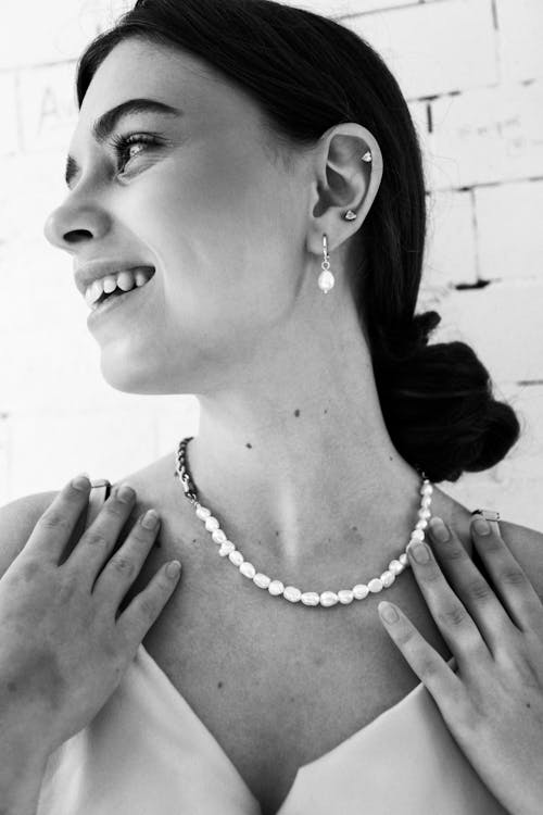 Grayscale Photo of a Woman Wearing White Necklace