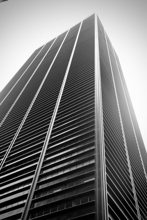 Free Striking black and white photo of a towering skyscraper in New York City captured from a low angle. Stock Photo