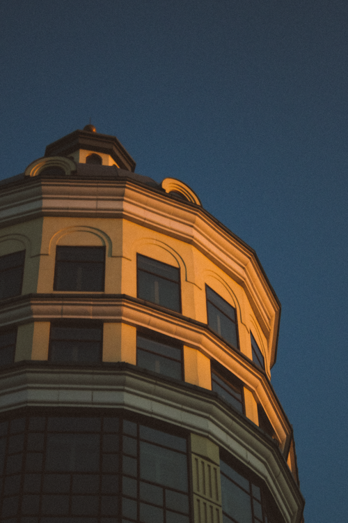 Free Close-up of an elegant building facade during twilight with striking shadows. Stock Photo