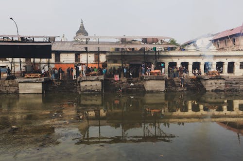 People Gathering on Shore of Polluted River