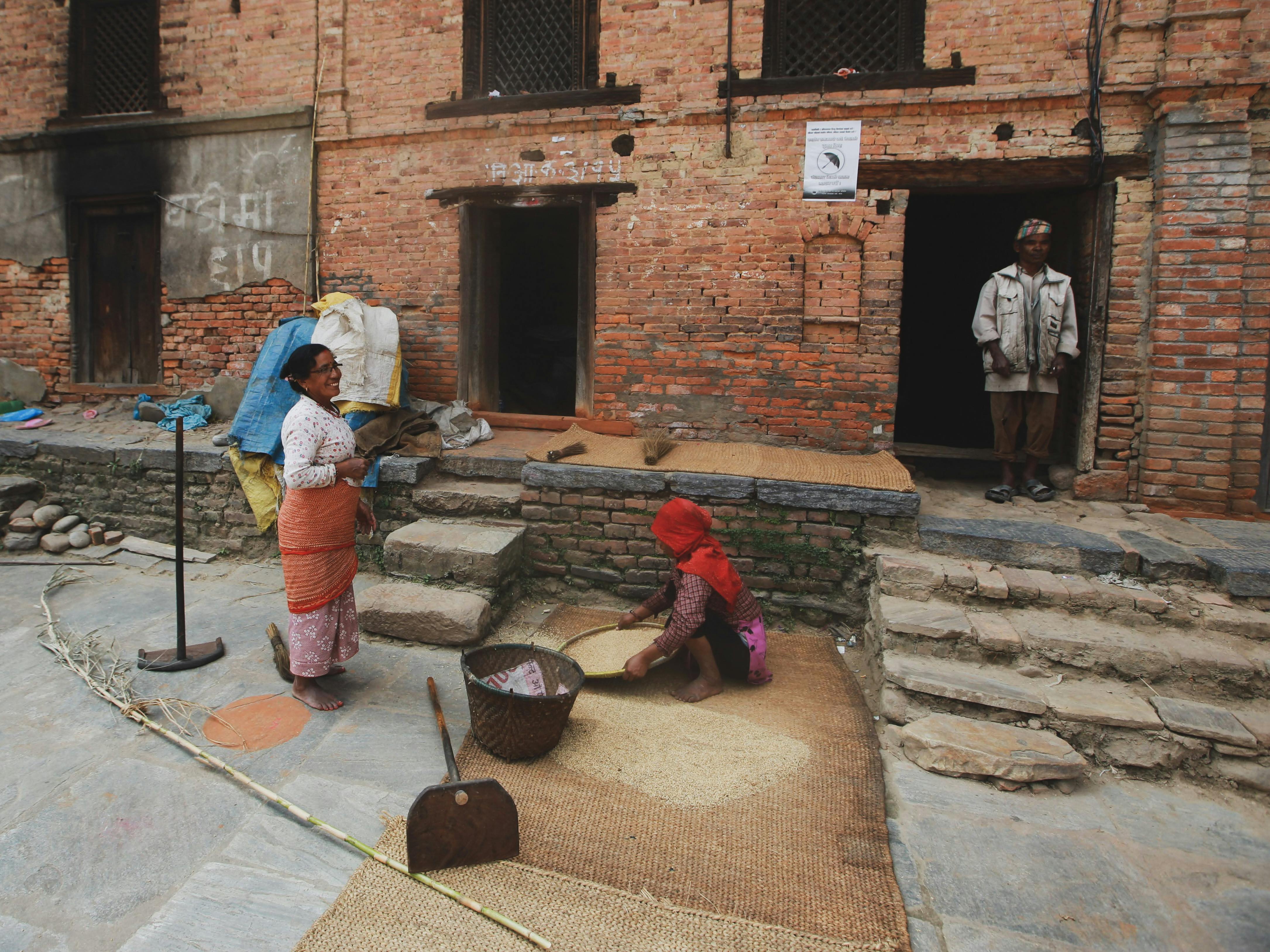 A family in front of a rustic brick building, showcasing daily urban life.