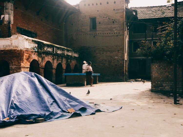 Woman In Yard With Old Brick Buildings