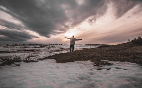 Person Standing on Snowy Field