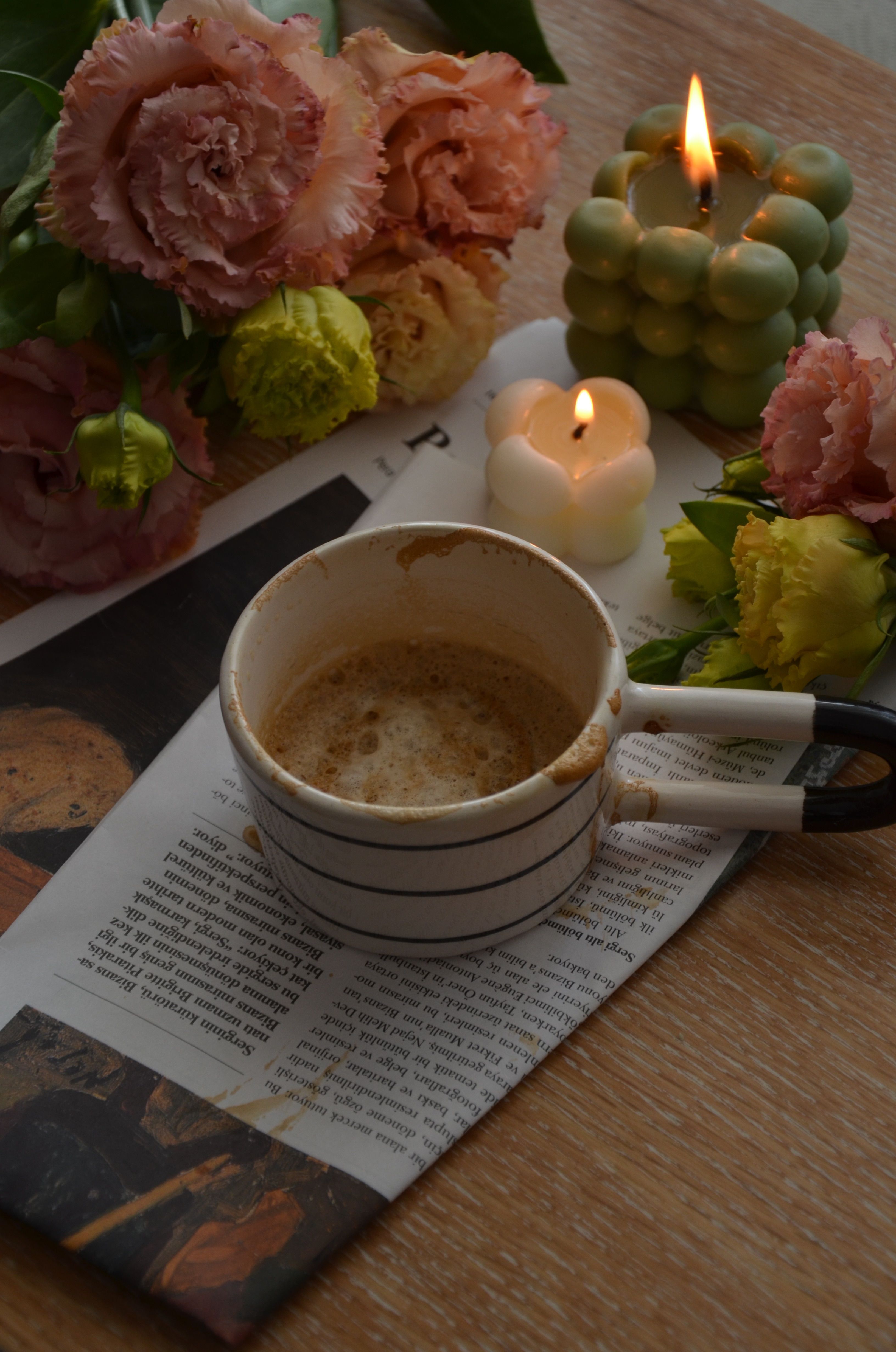 Warm coffee scene with flowers and candles for a cozy ambiance.