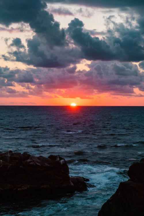 Free A breathtaking sunset over the ocean at Oaxaca, Mexico, with vibrant colors and dramatic clouds. Stock Photo