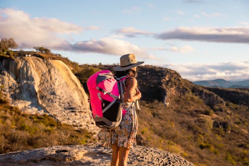 Teenage Girl in Floral Dress and Havana Hat Standing on a Rock