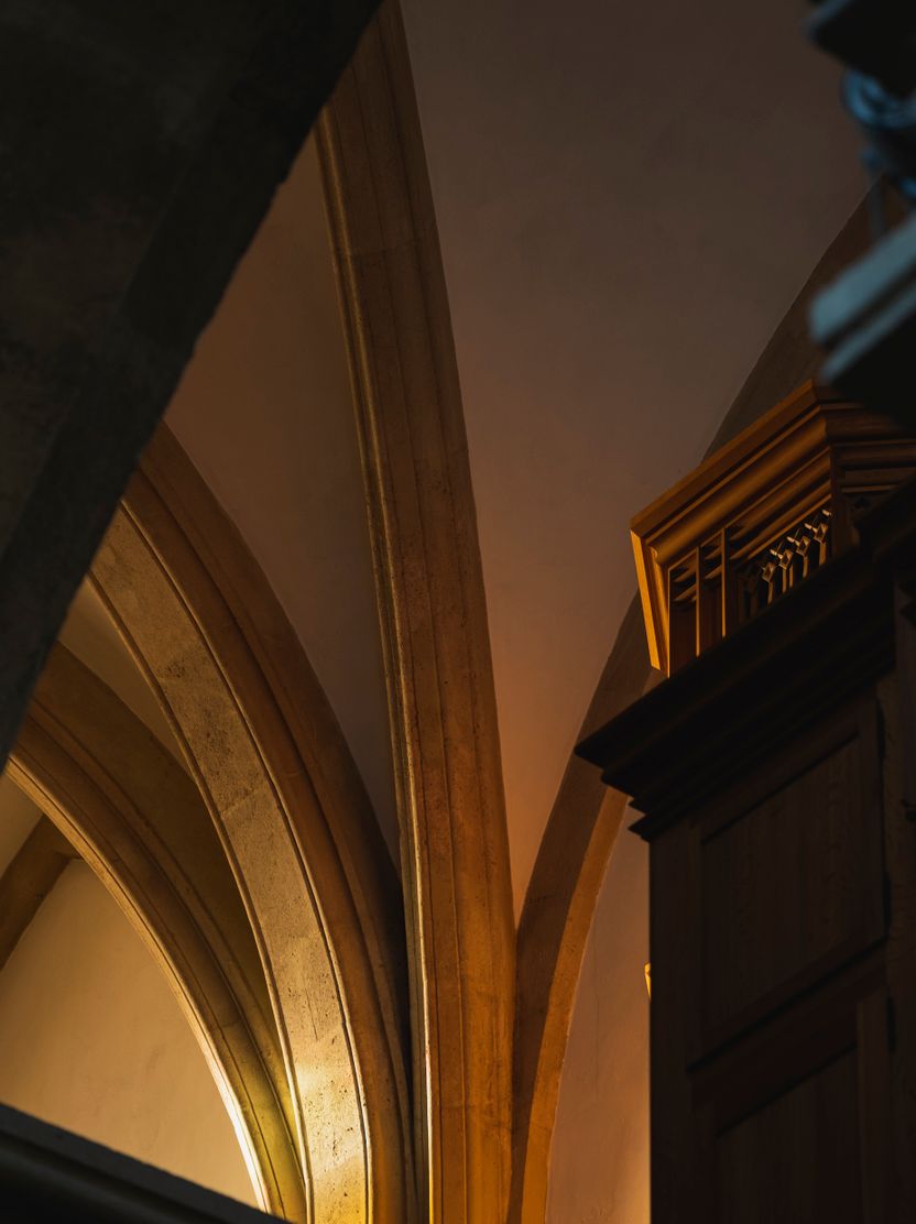 Vaulted stone arches lit from below in a gothic interior — photo by Michael Pointner on Pexels