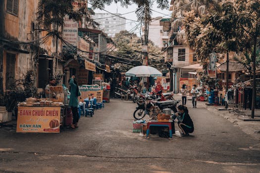 A bustling street food market in Vietnam with food stalls and people shopping. Captures the essence of street life.