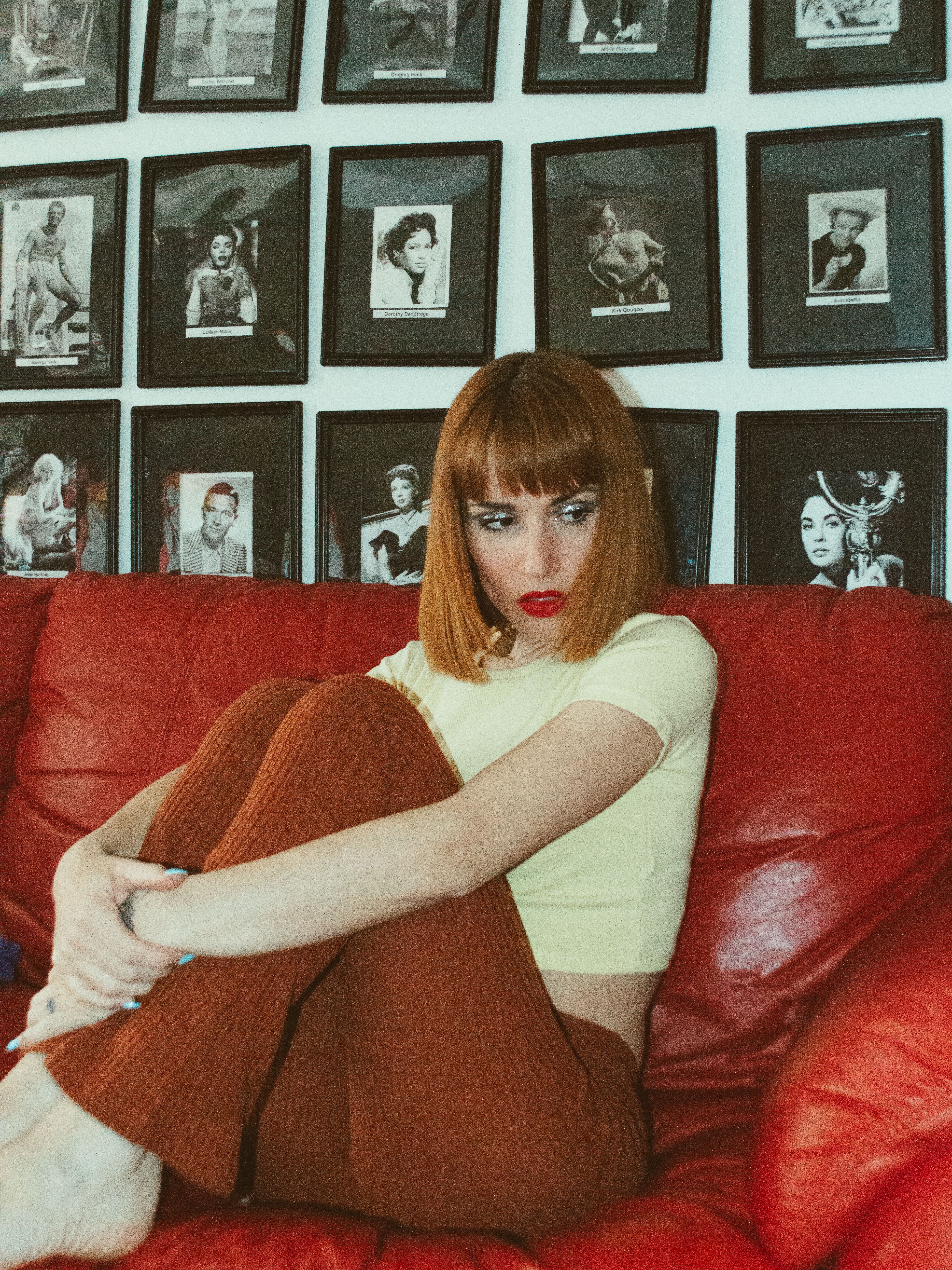 A woman laying on a bed with red hair and black shoes · Free Stock Photo