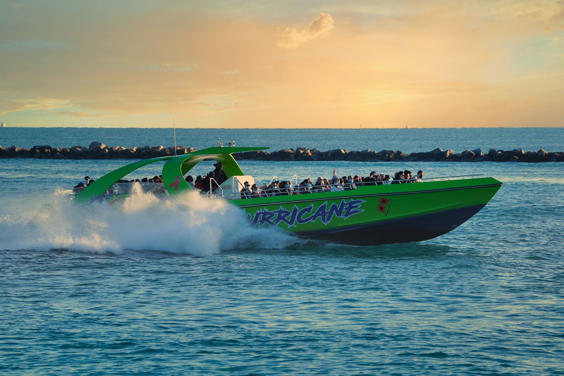 A lively motor yacht speeds across the ocean waves, capturing the thrill of the open sea at sunset.