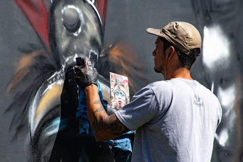Pria Memakai Lukisan Kaos Crew Neck Abu Abu Di Dinding