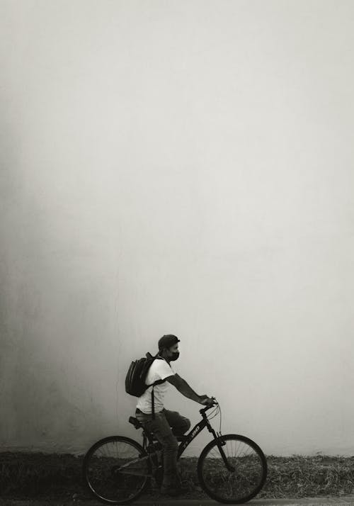 Black and White Photo of a Man Riding a Bicycle