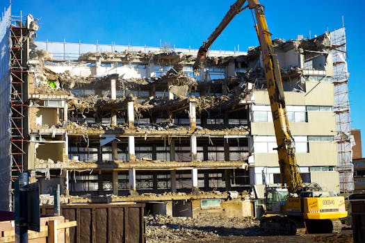 A building undergoing demolition with an excavator at work, capturing urban transformation.