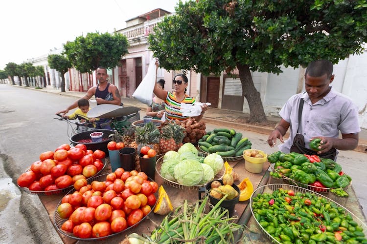 People Selling Fresh Fruit And Vegetables On A Market Stall 