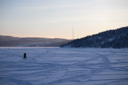 Riding a Snow Mobile over the Snow Covered Valley