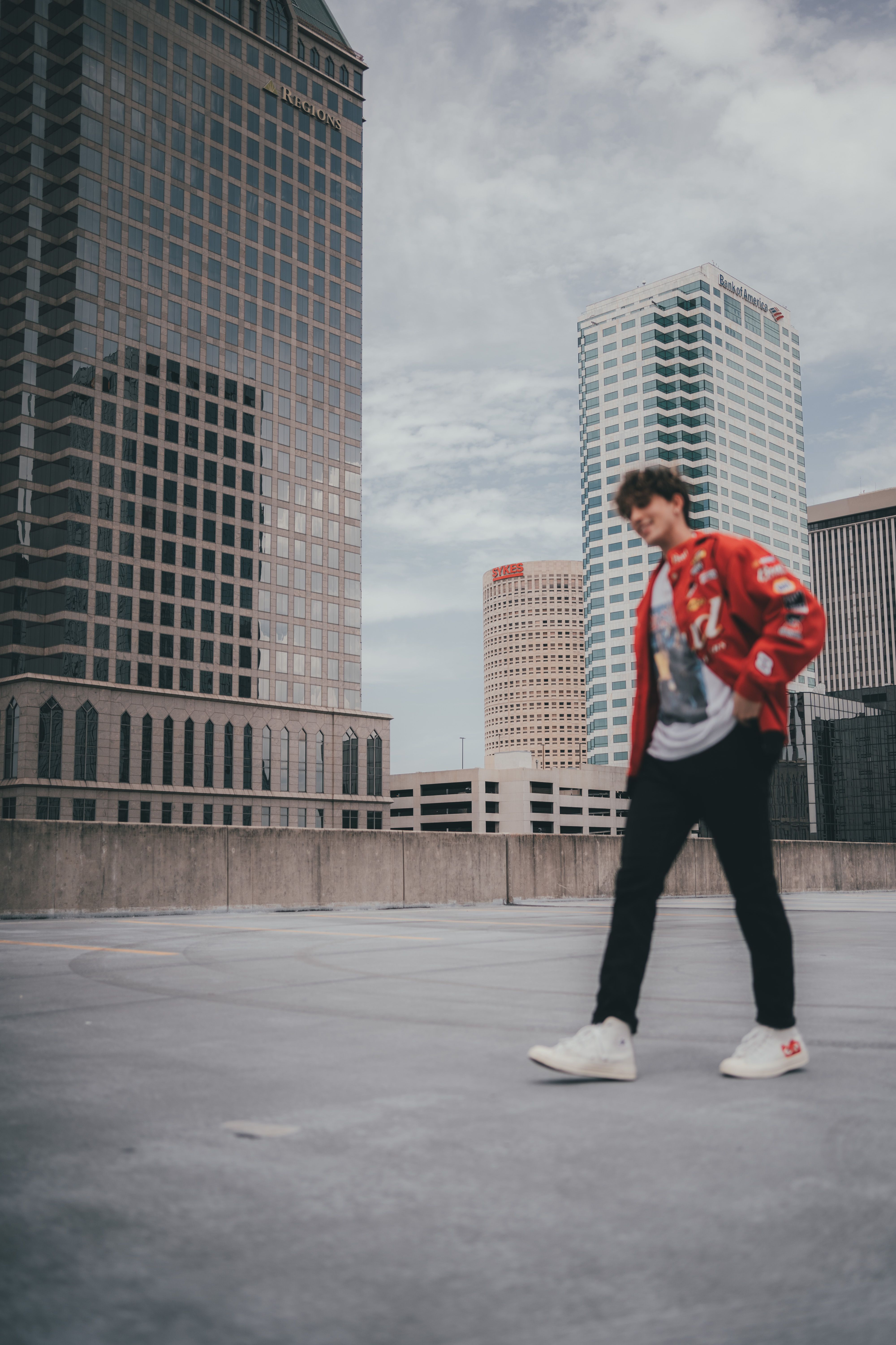 Photo of a Man Walking Near a High-Rise Building · Free Stock Photo