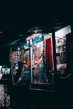 An atmospheric night market shop illuminated, showcasing diverse colorful products.