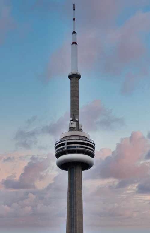 Free The CN Tower in Toronto stands tall against a backdrop of soft clouds at sunset. Stock Photo