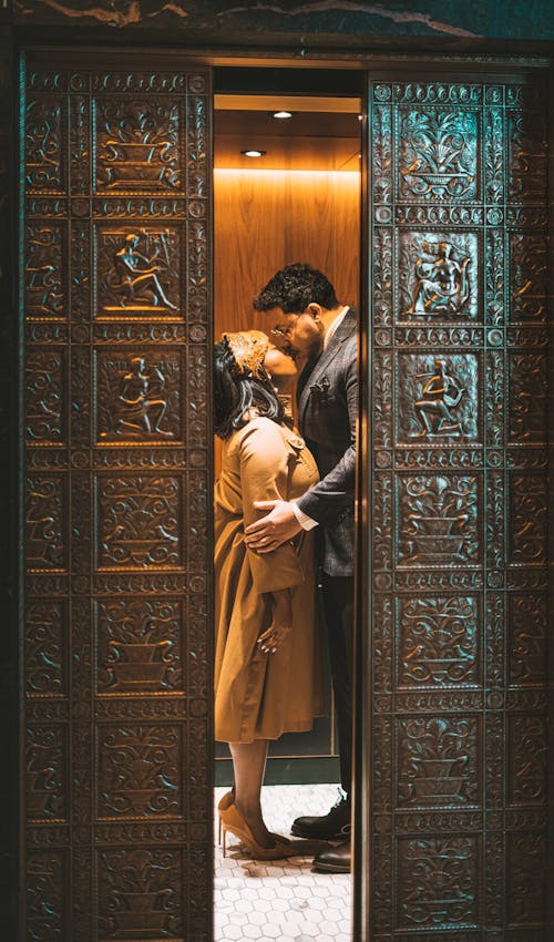 A Couple Kiss Each Other Behind the Door