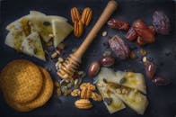 石板上放着奶酪片、坚果、枣和蜂蜜，这是一份令人愉快的零食组合