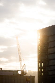 A stunning view of Toronto's skyline with a construction crane and sunset lighting up the sky.