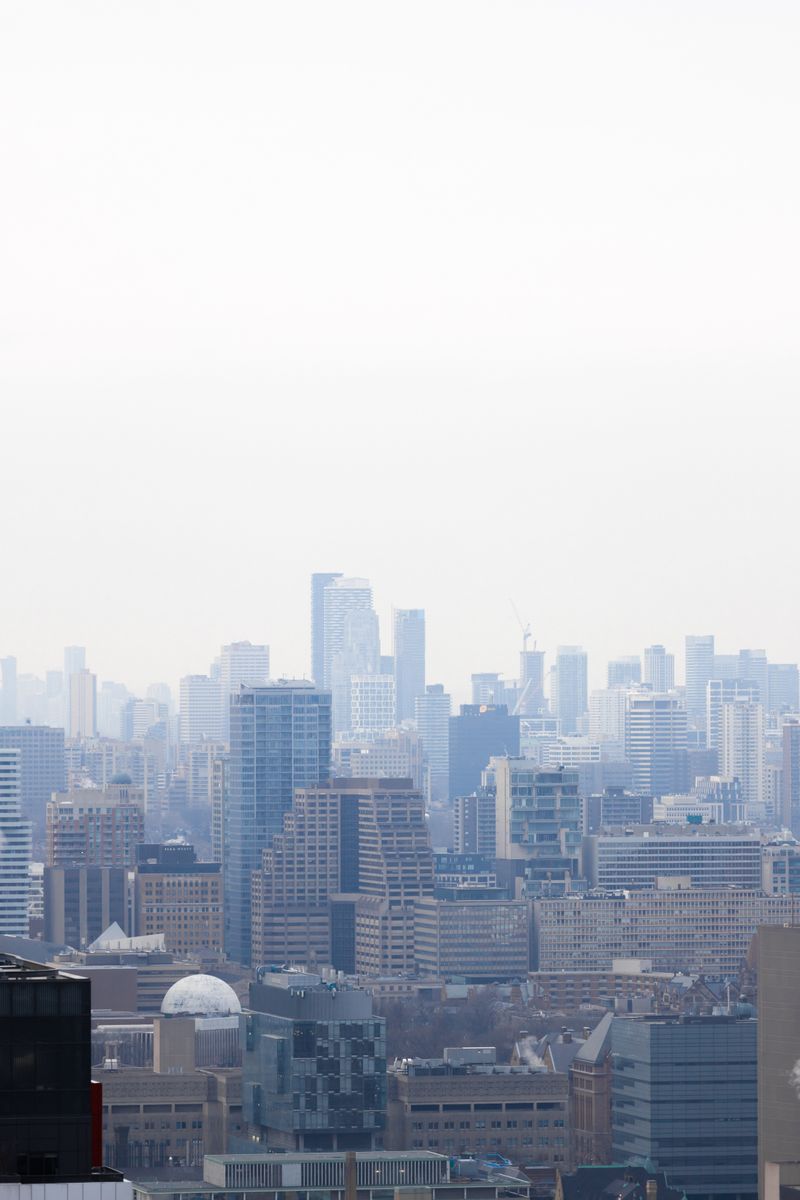 Toronto skyline with skyscrapers visible through a misty sky. Captured from an elevated perspective.