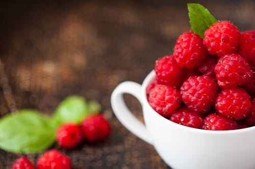 Free Ripe Raspberries in White Teacup in Tilt Shift Photography Stock Photo