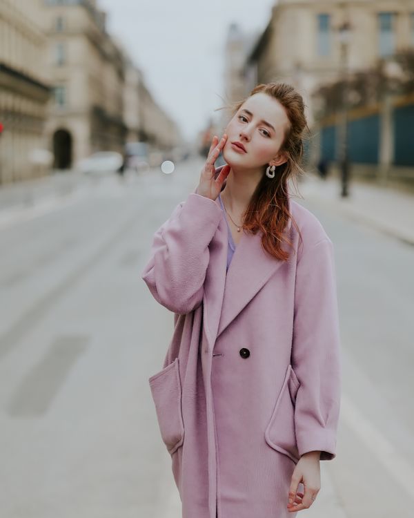Pale pink coat over white shirt and dark jeans