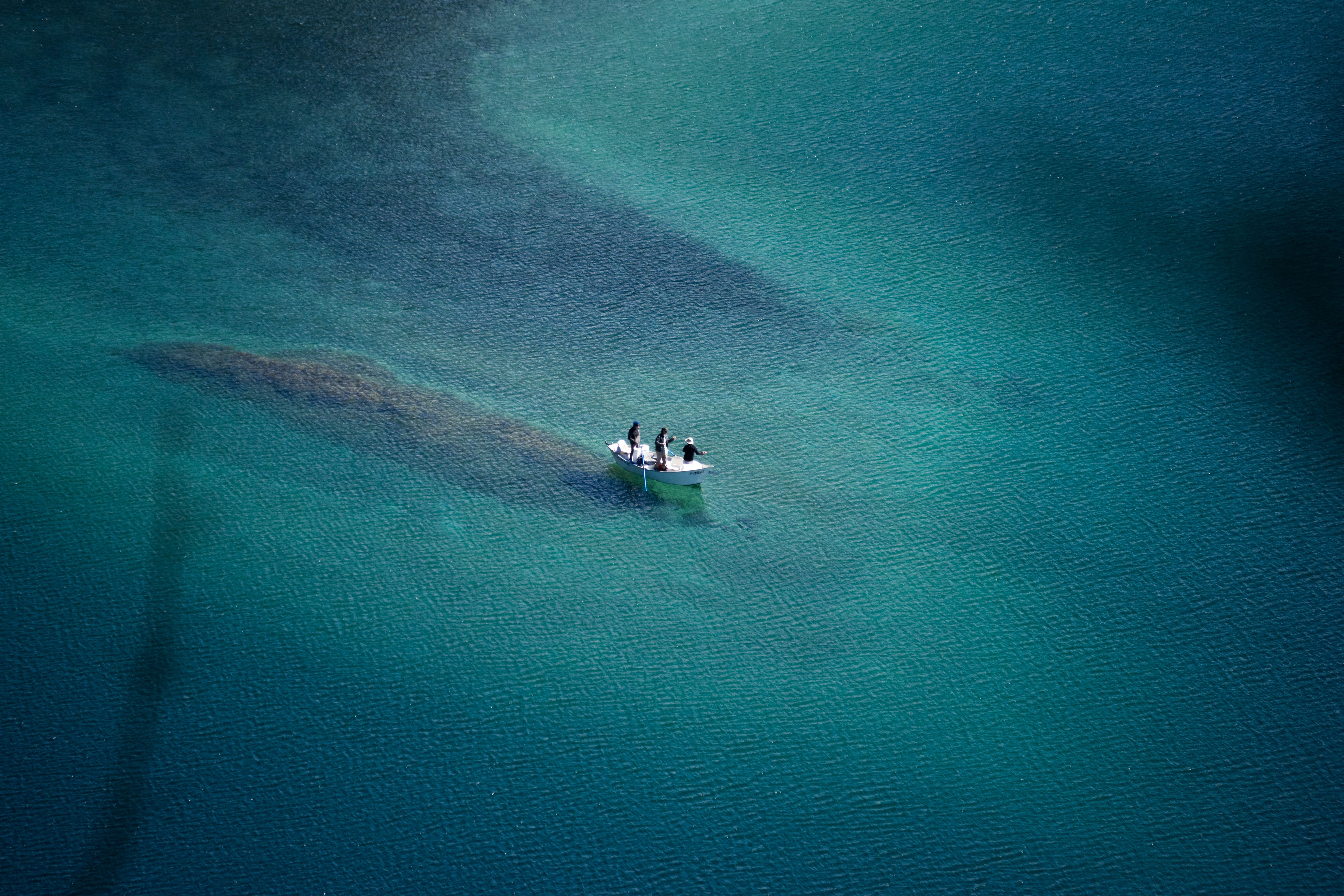 Aerial photo of a boat on turquoise lake waters